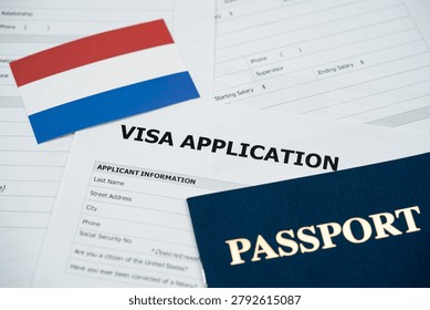 View of Netherlands visa application form with passport and national flag.