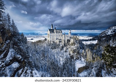 View of the Neuschwanstein Castle in winter during a snowstorm on a rugged hill of the foothills of the Alps, Schwangau, Bavaria, Germany - Powered by Shutterstock