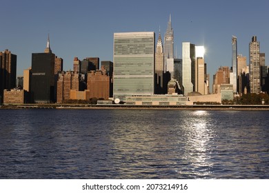 View Of New York City Skyline With United Nations Headquarters Seen From The East River At Sunrise. Manhattan Midtown Skyscrapers With UN Secretariat And General Assembly Buildings.