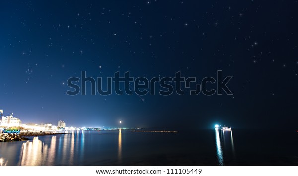 VIew of\
a night city with clear sky and a falling\
star
