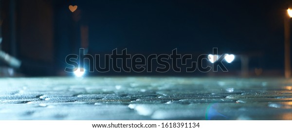 view of the
night street after rain on a background of blurry lights in the
shape of a heart, website
background