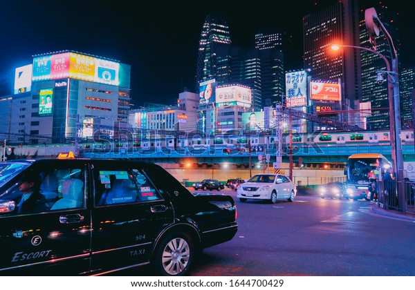 View to night Tokyo in Shinjuku district with\
lots of neon lights. 26 March, 2019. Future Funk Vibes. \
People,\
cars and trains.