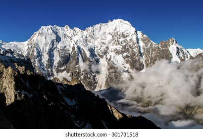 The view of north face of mount Dykh Tau in morning sunlight with a clear summit, in the mountains of the Russian Caucasus _