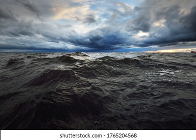 A view to the North sea from a sailing boat at sunset. Dramatic stormy sky, sun rays through the dark clouds. Epic seascape. Deep cyclone in winter. Norway. Concept image, climate change,  ecology
