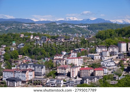 The view from the observation deck in the Upper part of Arboretum Park to the residential areas of Sochi on the snow-covered mountains background. Krasnodar Krai. Russia. Krasnodar Krai. Russia