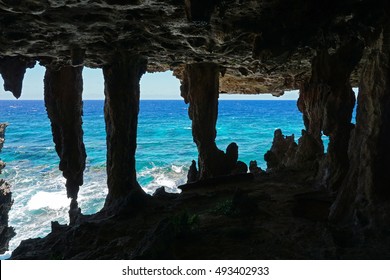View to the ocean from a cavern with stalactites and stalagmite in a cliff on the sea shore, Rurutu island, south Pacific, Austral archipelago, French Polynesia