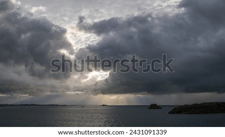 view of the ocean and small islands from Saint Malo, dramatic sky with clouds in summer