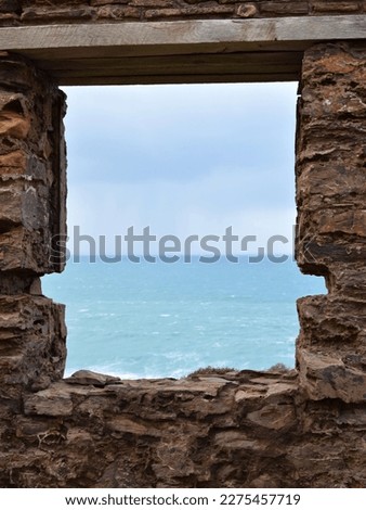 View of ocean surf through old cornish mine ruin windowframe