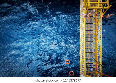 View Of An Offshore Crew Walking At The Gangway To Offshore Drilling Rig With Life Life Buoys 