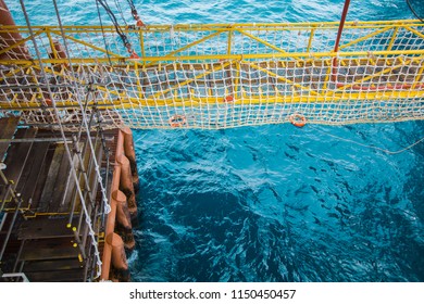 View Of An Offshore Crew Walking At The Gangway To Offshore Drilling Rig With Life Life Buoys 