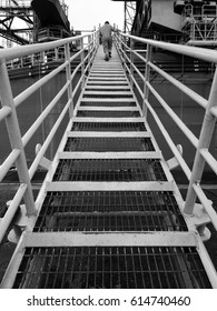 View Of An Offshore Crew Walking At The Gangway To Offshore Drilling Rig In Black And White. 