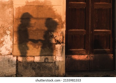 A view of old building door and wall with shadow of couple holding hands - Powered by Shutterstock