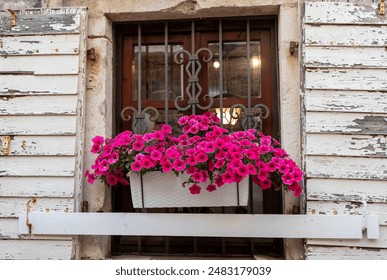 View of the old house. Wooden window. Pink flowers in pot. Famous places. Historic buildings and sights. - Powered by Shutterstock