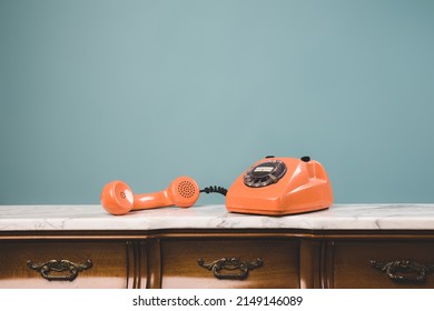 View Of An Old Retro Telephone With The Receiver Off The Hook On A Table.