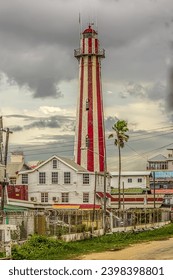 View of the old stone lighthouse tower in Georgetown, Guyana , South America against a background of a stormy sky with Cumulostratus clouds. Lighthouse - world tourism, attractions, landscape.