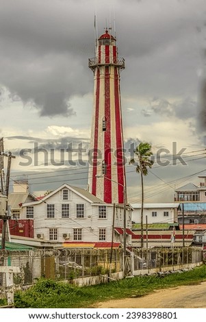 View of the old stone lighthouse tower in Georgetown, Guyana , South America against a background of a stormy sky with Cumulostratus clouds. Lighthouse - world tourism, attractions, landscape.