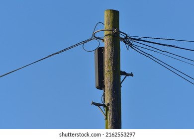 View of an Old Wooden Telegraph Pole against a Clear Blue Sky
