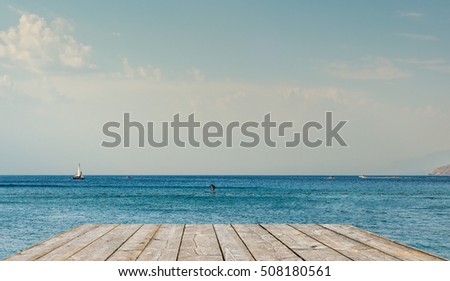 Similar – two straw beach umbrellas on an empty seashore on a clear day