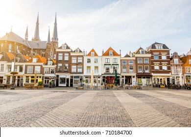 View on the beautiful buildings facades and church on the central square during the sunny morning in Delft city, Netherland