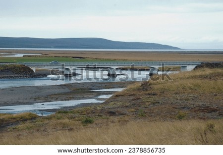View on a bridge on the Ring road number 1 over the Miðfjarðará river near Laugarbakki in the Norðurland vestra region with the Miðfjörður fjord in the distance