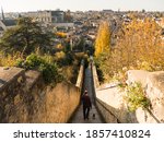 View on the city of Poitiers in France. There is a staircase. Someone goes down and walks his dog. Photographed in autumn.