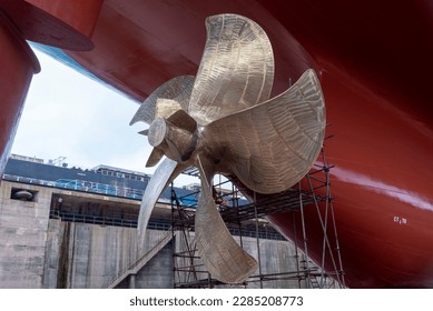 View on the container ship propeller. Ship is inside a dry dock for routine maintenance and painting.