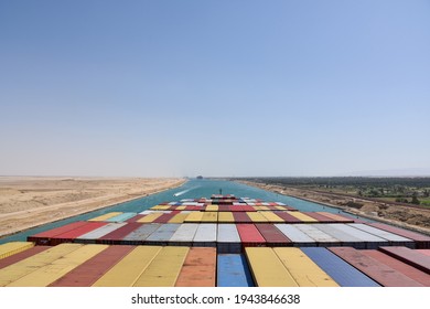 View on the containers loaded on deck of cargo ship. Vessel is transiting Suez Canal on her international trade route. Suez canal landscape.