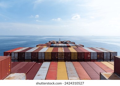 View on the containers loaded on deck of the large cargo ship. She is sailing through calm, blue ocean.  - Powered by Shutterstock