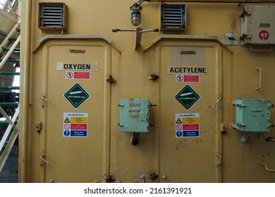 View on the cream metal doors with warning stickers for gas bottle store of oxygen and acetylene bottles using for welding and fame cutting. Storage room is situated on the merchant cargo vessel.