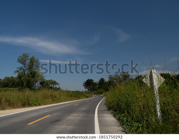 A view\
on the curved road, on the road overlooking the traffic sign. With\
far side, picture Is a view of the mountains and the sky that can\
be seen comfortably On the day of our\
trip\
