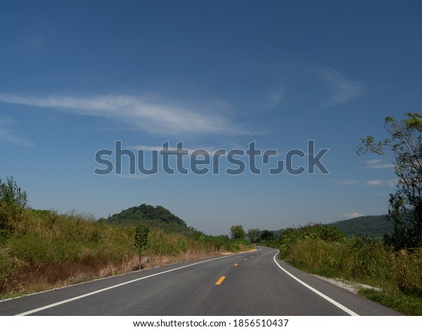A view on\
the curved road, on the road overlooking the traffic sign. With far\
side, picture Is a view of the mountains and the sky that can be\
seen comfortably On the day of our\
trip