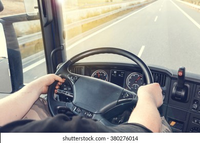 View On The Dashboard Of The Truck Driving. The Driver Is Holding The Steering Wheel. Empty Highway Is In Front Of The Car. Edited As  Instagram Effect And Used Lens Flare Effect.