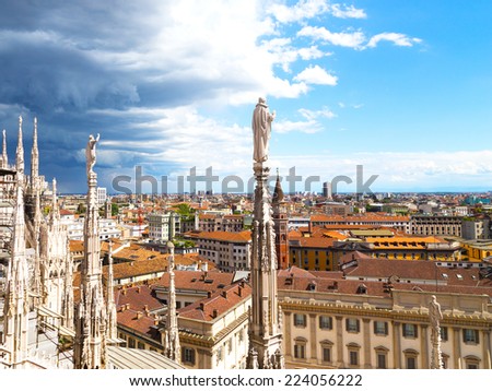 View on downtown from height of the Dome of Milan cathedral. Contrasting skies over roof tops of Milan downtown.