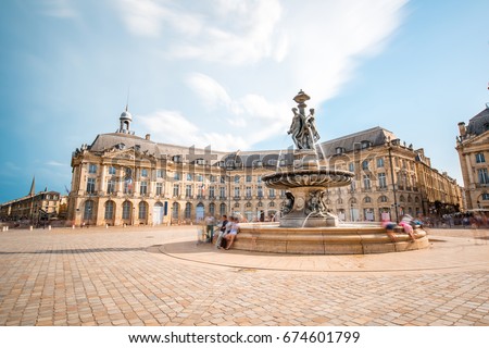 View on the famous La Bourse square with fountain in Bordeaux city, France. Long exposure image technic with motion blurred people and clouds
