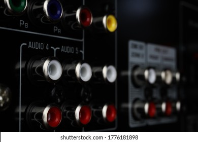View on isolated cinch sockets of back side of black dolby surround receiver in arow