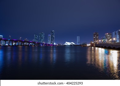 View on Miami Downtown and MacArthur Causeway at night time with a view on a bay, wallpaper or poster. USA