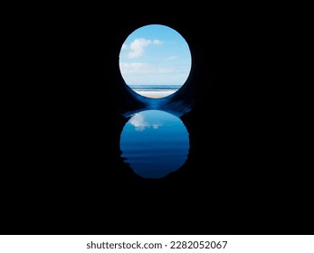 View on the ocean from a pipe or round shape hole with reflection inside the pipe. Abstract nature concept. Blue cool tone. Artificial framing of nature.