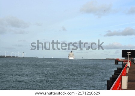 A view on the Port of Rotterdam at  New Waterway (Nieuwe Waterweg) ship canal in North Sea at Hoek Van Holland, The Netherlands. MS Iona Southampton and wind turbines in the distance. Space for copy. 