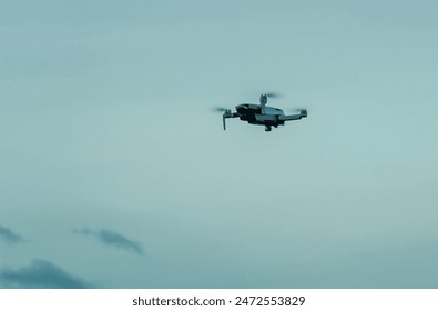 View on quadcopter drone flying in the evening sky. Remote controled drone with photo video camera. - Powered by Shutterstock