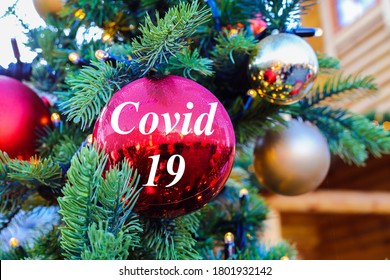 View on red glitter ball on fir tree with covid 19 text at christmas market