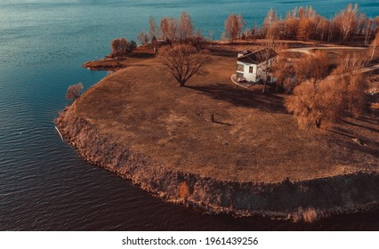 View on red holiday cabin by a lake in Stockholm archipelago, Sweden. Wooden cottage, sauna on shore. Tiny house near the water. Rocky small island, islet in water. Buildings surrounded by green trees - Shutterstock ID 1961439256