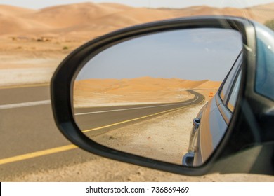 View On The Road Going Through Sandy Dunes Of Rub Al Khali Desert Seen Through Car Side View Mirror, United Arab Emirates