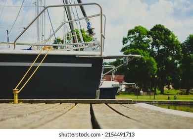 View On Sailboat Moored On Wooden Jetty In The Port, Close Up View On Sailboat Hull And Bow