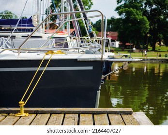 View On Sailboat Moored On Wooden Jetty In The Port, Close Up View On Sailboat Hull And Bow