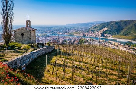 View on the Saint Christophe Chapel and the city of Tain l'hermitage with blooming red poppies and the vinyards of Chapoutier winery in the foreground