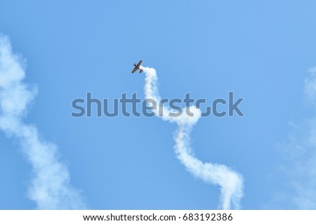 View on sport plane vapour trail in shape of spiral. White vapour trail track on blue sky background. Sport plane Aerobatic maneuver stunt. Spinning plane vapor trail in the sky. Stock photo © 