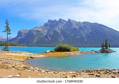 The view on the tiny island and pine trees at turquoise Lake Minnewanka, AB. Rocky mountain in the background. Banff National Park, AB. - Powered by Shutterstock