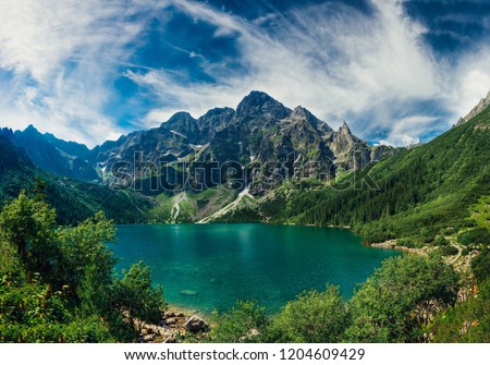 View on the turquoise color lake between high and rocky mountains. Beautiful alpine landscape. 
