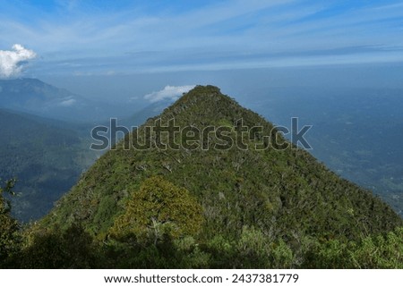 View from one peak to its twin of the dethanagala mountain located in Sri Lanka,behold lush green forests against blue skies and clouds—a natural scenary for hiking and trekking enthusiasts.