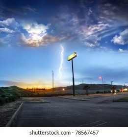 A View Of Open Space And Lonely Highway Road On The Outskirts Of A Glowing City At Sunset